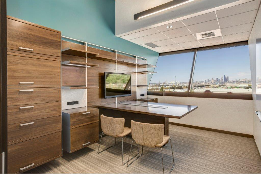 Open Square office with wood desk and cabinets, and Seattle view