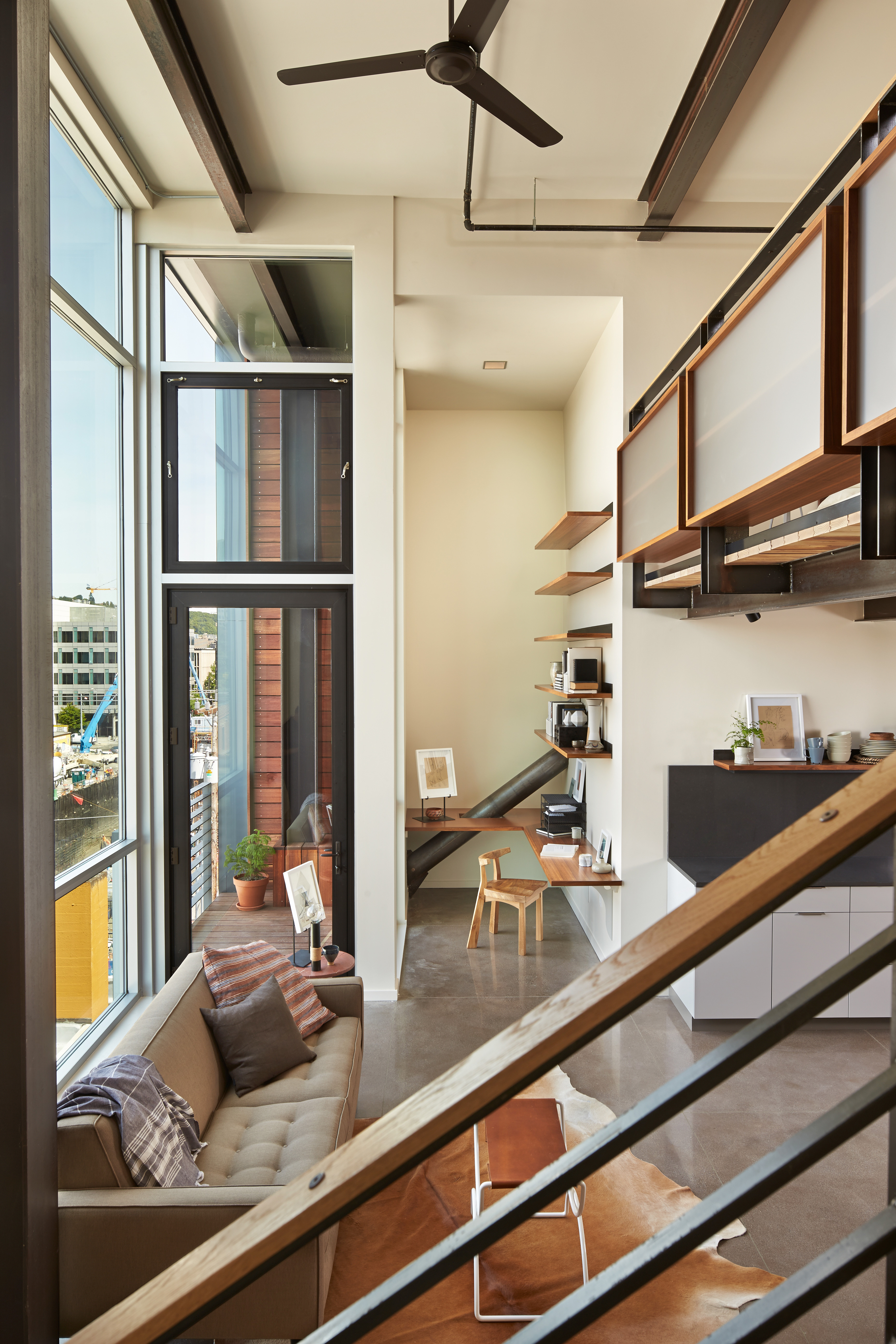 Looking down on living space interior from balcony staircase